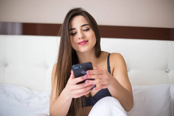 mulher sorrindo com celular na mão